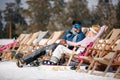 Winter holiday, ski, travel - couple relaxing together in sun at Royalty Free Stock Photo